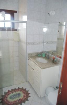 Banheiro social com gabinete, ducha higiênica e box em blindex